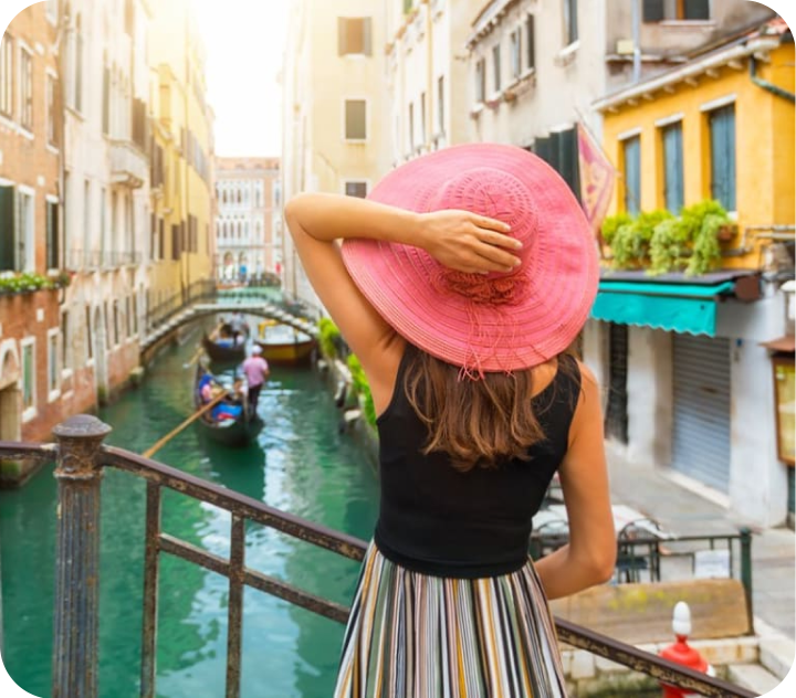 Woman Wearing Hat While Standing by Railing in Venice Canal